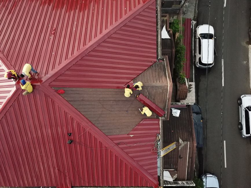 Attic ventilation inspection with natural light streaming through windows, wooden beams visible with golden hour tones